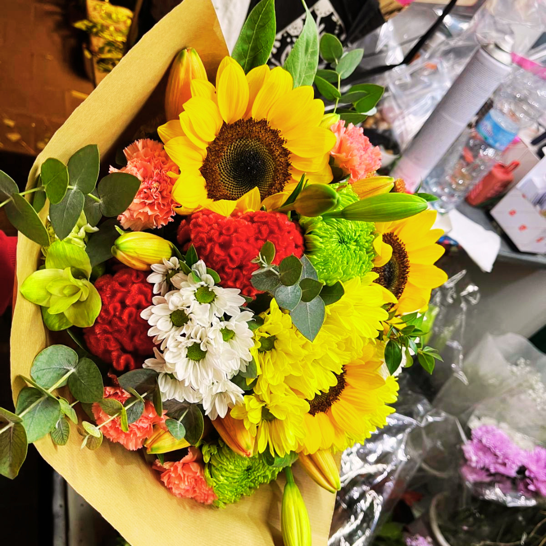 Bouquet con margherite, girasoli e celosia